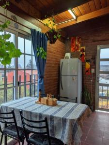 a kitchen with a table with chairs and a refrigerator at Casas de campo Traslasierra in Villa Cura Brochero