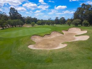 an aerial view of a golf course with a large sand bunker at Villa in the Valley in Pokolbin