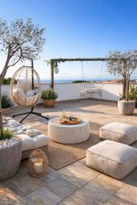 a patio with white chairs and a table and a swing at Residenza Cunto in Castellabate