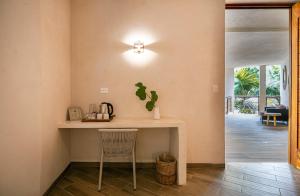 a table in a room with a chair and a light at Los Arrecifes in Tulum