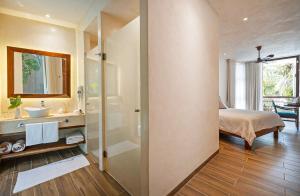 a bathroom with a shower and a sink and a bed at Los Arrecifes in Tulum +85 photos