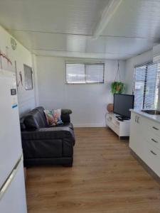 a living room with a couch and a tv at BIG4 Eagle Point Caravan Park in Eagle Point
