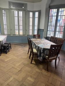 a dining room with a table and chairs and windows at hostel family in Santiago