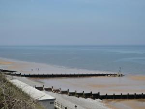 a beach with a pier in the water at Wisteria Cottage in Aylsham
