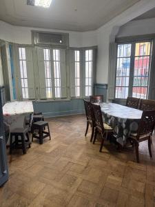 a dining room with a table and chairs and windows at hostel family in Santiago +9 photos