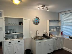 a kitchen with white cabinets and a sink and a window at 25 Lux Room 6 - 1 Queen Bed, Shared Bathroom - Nonsmoking in Arlington