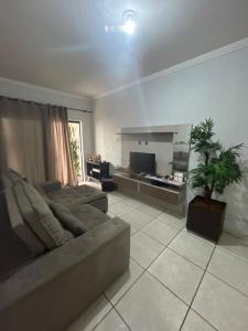 a living room with a couch and a television at Casa BIG John 3 mato grosso in Divinópolis