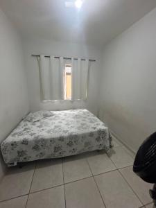 a small bed in a white room with a window at Casa BIG John 3 mato grosso in Divinópolis