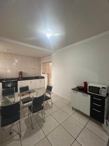 a kitchen with a table and chairs in a room at Casa BIG John 3 mato grosso in Divinópolis