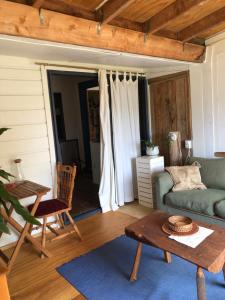 a living room with a couch and a table at Dragon's Den - self contained unit in Takaka