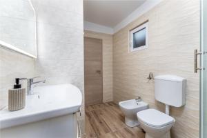 a white bathroom with a toilet and a sink at Camp Panorama with pool in Drage +37 photos