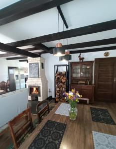 a living room with a fireplace and a table and chairs at Mazurska Chata Rydzewo in Rydzewo +41 photos