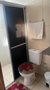 a bathroom with a toilet with a glass shower door at Casa Temporada Peter in Tutóia