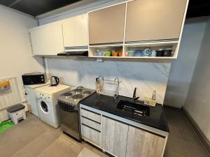 a kitchen with a stove and a sink and a dishwasher at Loft Neuquén in Neuquén +4 photos