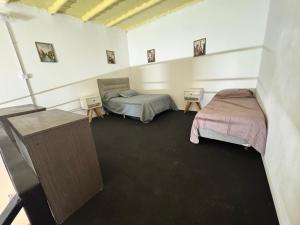 a room with two beds and a table in it at Loft Neuquén in Neuquén