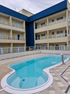 a swimming pool in front of a building at Recanto Ubaduba in Ubatuba
