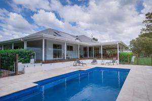 a house with a swimming pool in front of it at Terara Riverview Estate in Terara