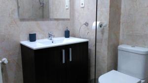 a bathroom with a sink and a toilet and a mirror at Madrid Rent 3 in Madrid