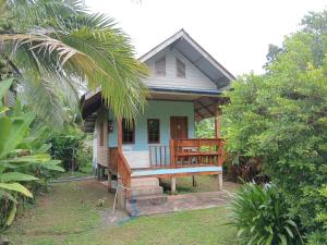 a small house with a porch and a bench outside at Cha Bungalow in Ko Yao Noi