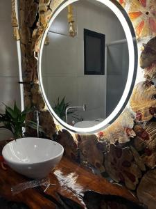 a bathroom with a sink and a mirror at Chalé Rio Capetinga 01 in Anchieta