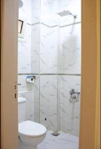 a bathroom with a toilet and a glass shower at Hana Grand Hotel in Madinat Al Ashir min Ramadan +24 photos