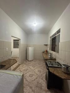 a kitchen with a stove and a refrigerator at Casa BIG John 4 Bahia in Divinópolis