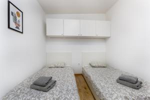 two beds in a room with white walls at Camp Panorama with pool in Drage