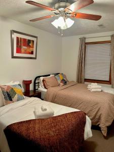 a bedroom with two beds and a ceiling fan at Comfortable 2BR-2BA Mountain Getaway Near Slopes in Cortland