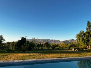 a swimming pool with a view of a field and mountains at Alalá Campo in Pocito