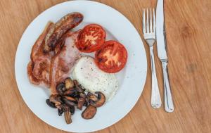 a plate of food with eggs bacon tomatoes and mushrooms at Treweens in Wadebridge