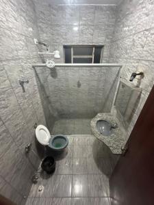a bathroom with a toilet and a sink at Casa BIG John 5 Bahia in Divinópolis