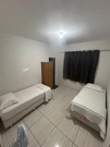 a room with two beds and a window in it at Casa BIG John 5 Bahia in Divinópolis
