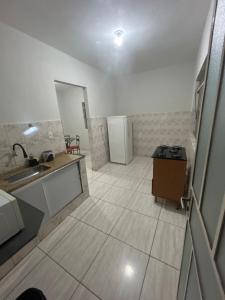 a kitchen with a sink and a refrigerator at Casa BIG John 5 Bahia in Divinópolis