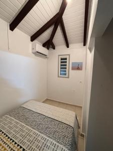 a bedroom with a bed in a white room at Bungalow Cécilia in Petit-Bourg