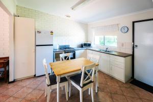 a kitchen with a wooden table and a white refrigerator at Middleton Mews in Albany