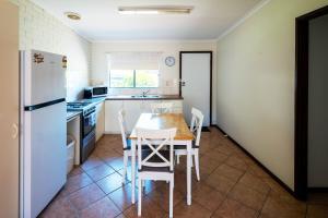 a kitchen with a table and a white refrigerator at Middleton Mews in Albany +9 photos