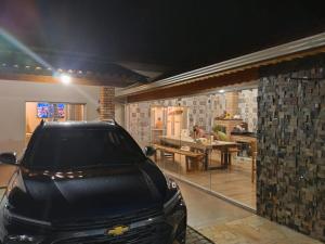 a black car parked in a garage with a table at Chácara Lari & Sapão in Socorro