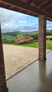 a stone patio with a large rock in the background at Chácara Lari & Sapão in Socorro