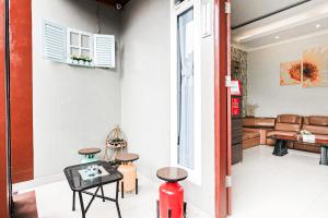 a living room with a couch and a table and chairs at RedDoorz Syariah Near Jam Gadang Bukit tinggi 2 in Bukittinggi