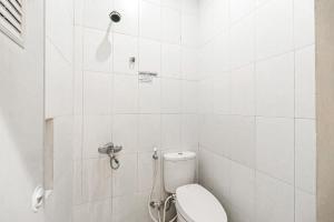 a white bathroom with a toilet and a shower at RedDoorz Syariah Near Jam Gadang Bukit tinggi 2 in Bukittinggi +17 photos