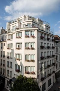 - un bâtiment blanc avec des balcons sur le côté dans l'établissement Hôtel Parc Saint-Séverin - Esprit de France, à Paris
