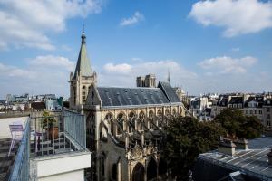 a building with a steeple on top of a city at Hôtel Parc Saint-Séverin - Esprit de France in Paris