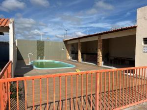 a house with a swimming pool on a deck at Casa Temporada Peter in Tutóia