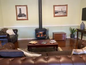 ein Wohnzimmer mit Sofa und Kamin in der Unterkunft Loggers Rest B&B in Stanthorpe