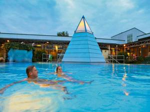 a man and woman swimming in a swimming pool at Geräumiges Studio in Bad Birnbach in Bad Birnbach