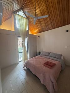 a bedroom with a large bed with a wooden ceiling at Casa EMMA Girardot in Girardot +19 photos