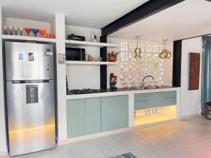 a kitchen with a stainless steel refrigerator in a room at Casa EMMA Girardot in Girardot