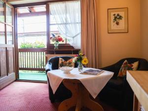 a room with a table with flowers on it at Gemütliches Studio in Bad Birnbach mit Terrasse in Bad Birnbach