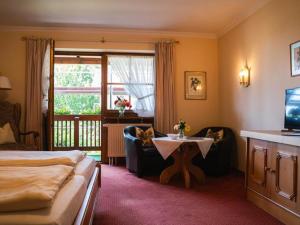 a hotel room with a bed and a table and chairs at Gemütliches Studio in Bad Birnbach mit Terrasse in Bad Birnbach +32 photos