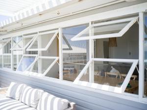 a screened porch with white windows and a couch at Walters in East Ballina